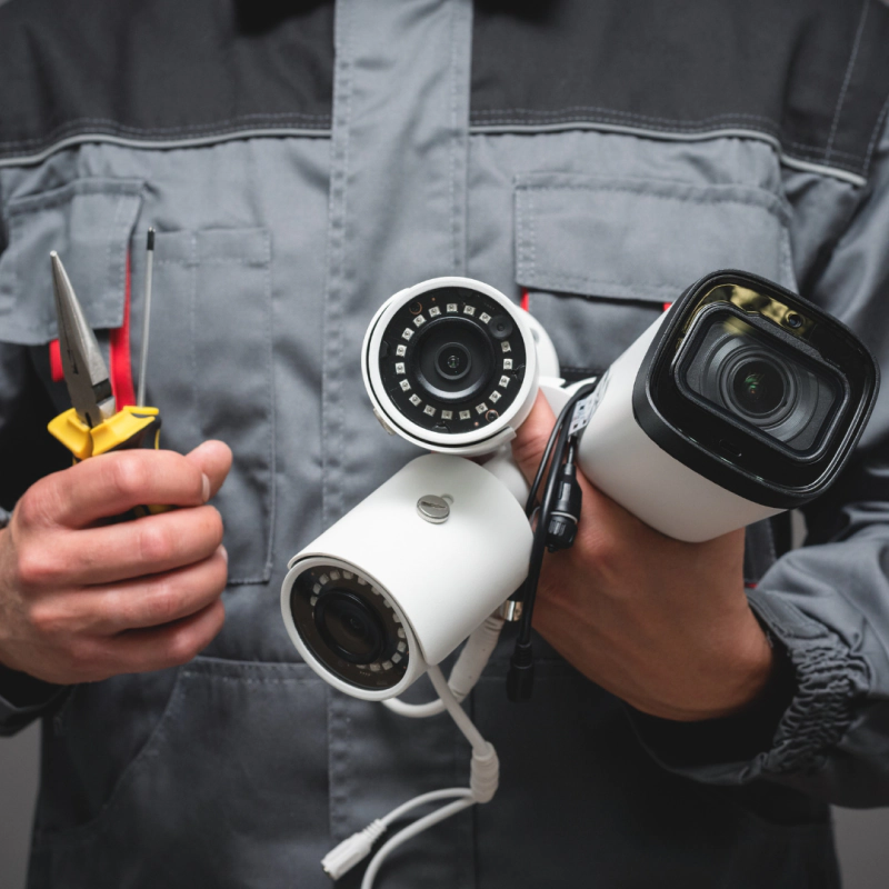 a person holding security cameras ready for installation